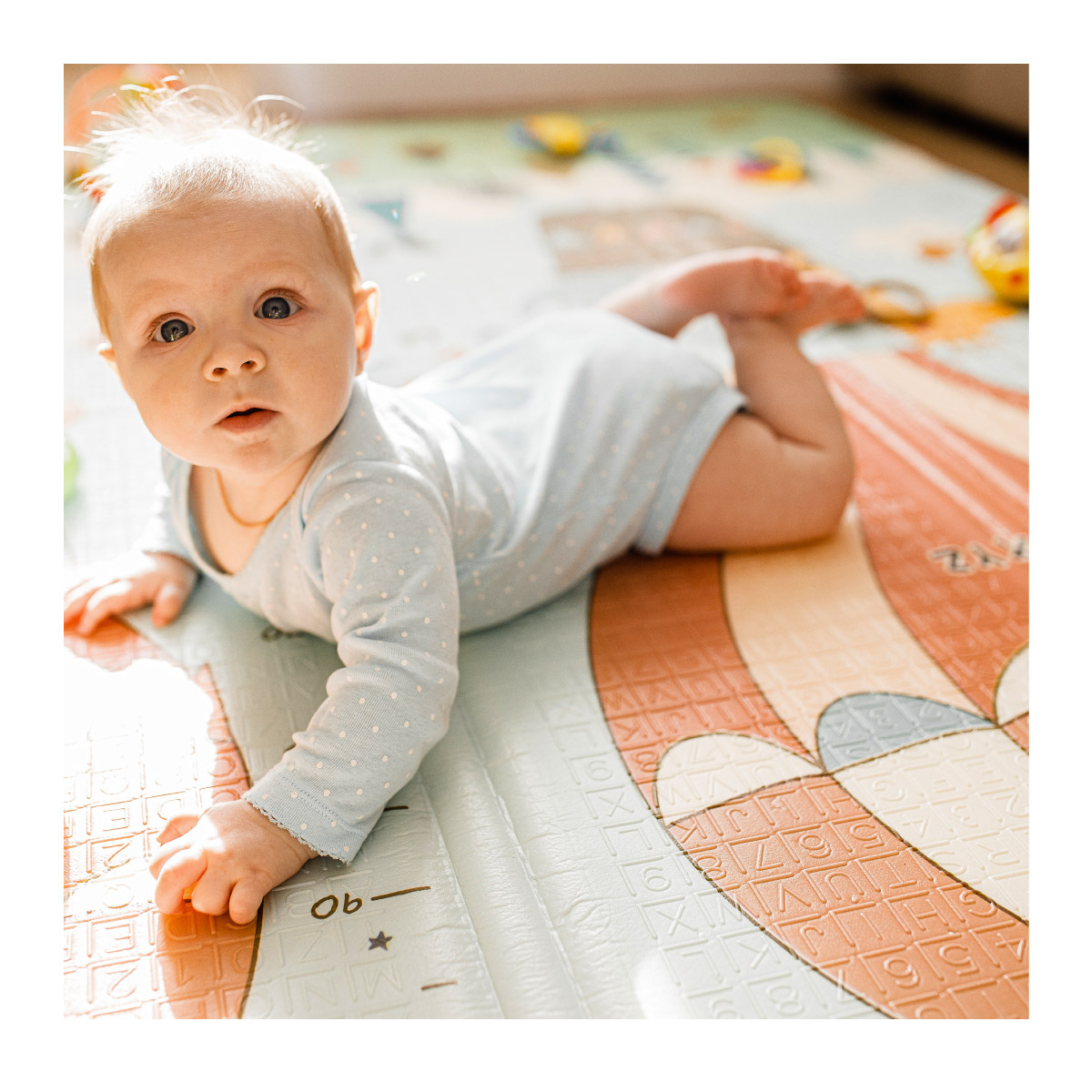 Mažas vaikas guli ant kilimėlio 
